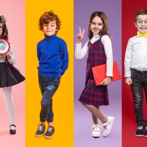 Diverse little schoolgirls and schoolboys against vibrant background in studio