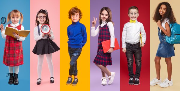 Diverse little schoolgirls and schoolboys against vibrant background in studio