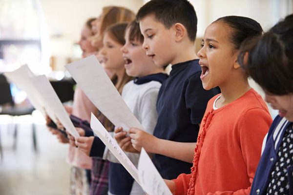 Group Of School Children Singing In Choir Together