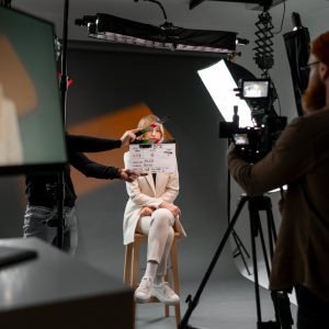 Woman gestures with clapper board in front of man, creating fun event display