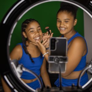 Diverse Teen sisters doing make up classes at home