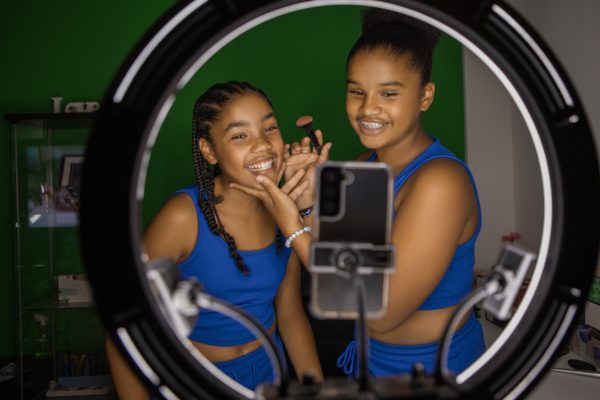 Diverse Teen sisters doing make up classes at home