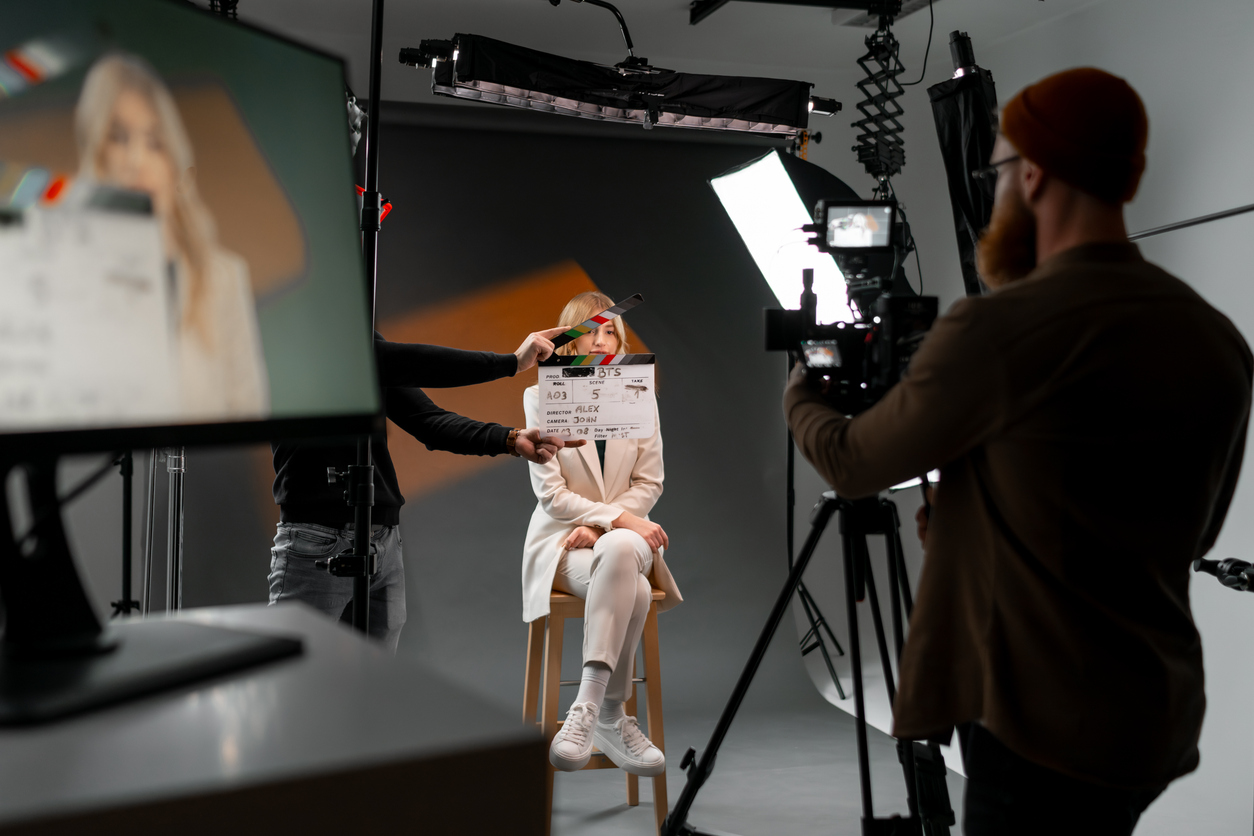 Woman gestures with clapper board in front of man, creating fun event display